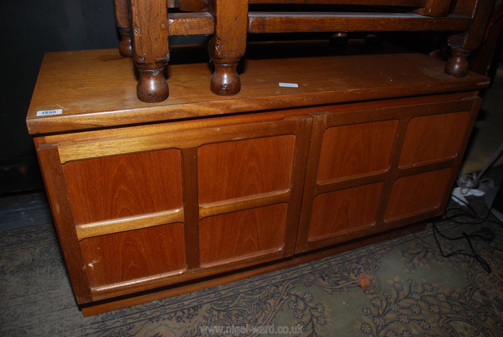 A 1960/70's low Teakwood Cupboard having a pair of opposing four panel doors,