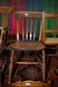 A traditional lath back solid seated kitchen chair having turned legs and 'H' stretchers.