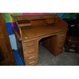 A mid Oak double pedestal scrolling roll-top Desk, the interior with pigeon holes and a drawer,