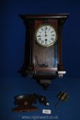 A darkwood and glass cased wall clock with key and pendulum, finials, a/f.