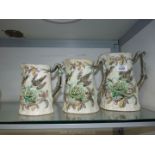 Three graduated jugs decorated with embossed birds feeding and chicks in a nest,