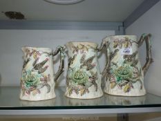 Three graduated jugs decorated with embossed birds feeding and chicks in a nest,