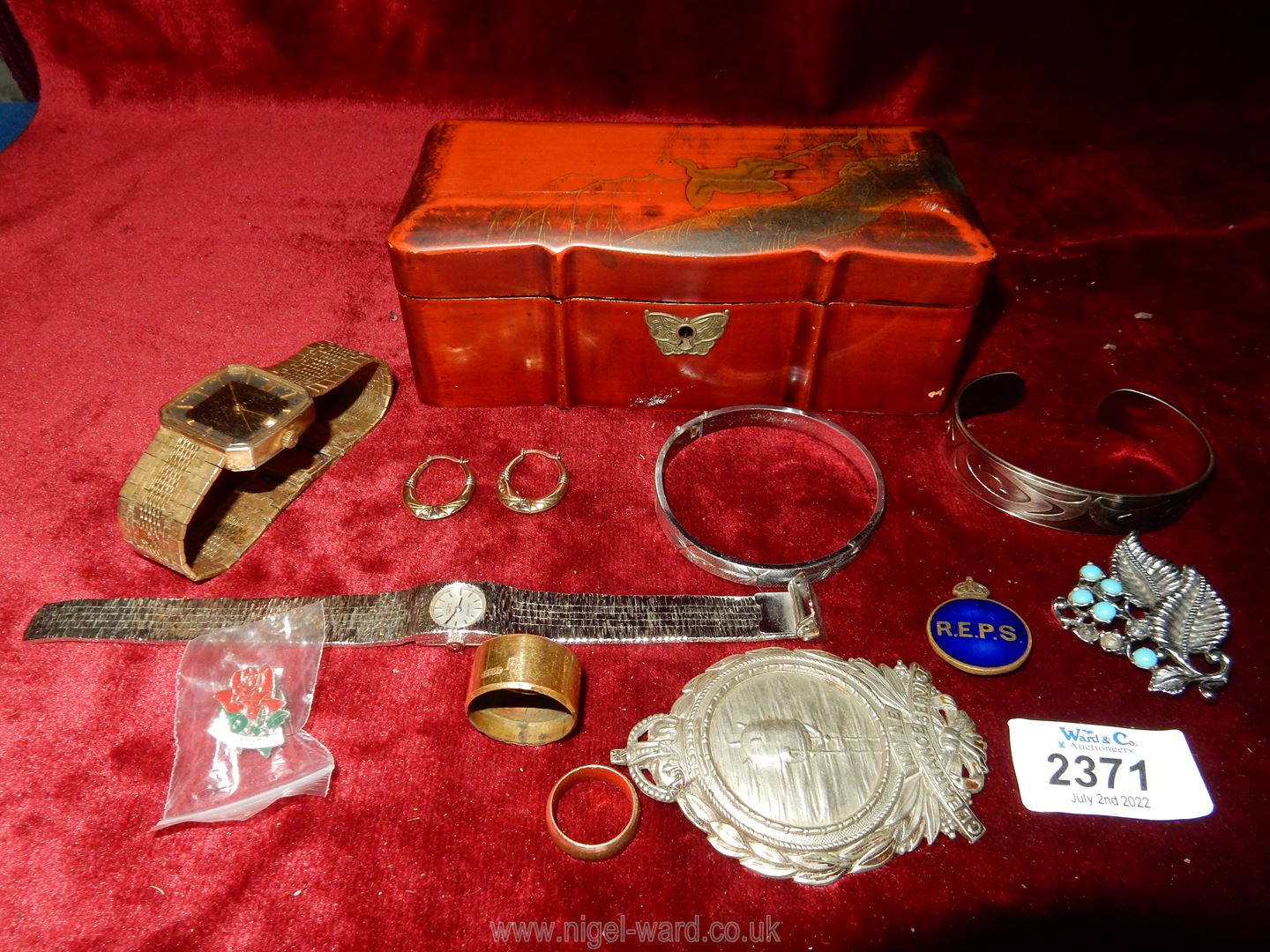 A small red lacquered oriental box and contents including an 18ct gold walking stick band by HF &