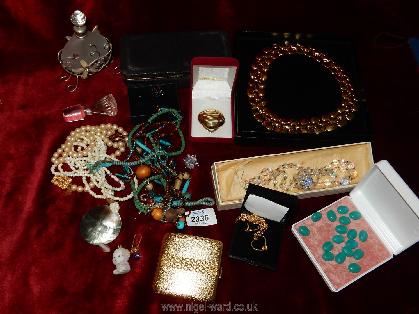 A box of mixed jewellery including a leather travel purse with mirror, pearls, a glass necklace,