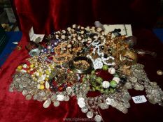 A quantity of miscellaneous costume jewellery including beads, brooches, cuff bracelet, etc.