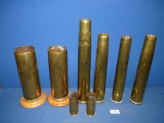 Eight brass shell casings including two small casings, one engraved for a 37mm gun,