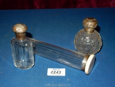 Three silver lidded glass scent bottles in various sizes including one with B.J.P.