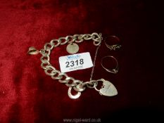 A heavy Silver chain Bracelet with three charms including a policeman's helmet, two silver rings,