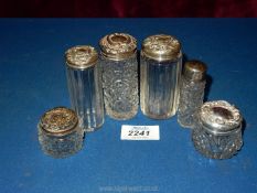 Four glass scent bottles with Birmingham silver lids most having applied/engraved decoration,