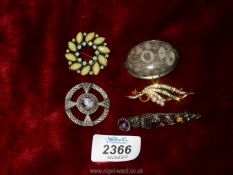 Five costume brooches including Celtic style, polished stone, etc.