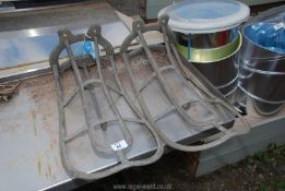 A pair of metal saddle racks 'Cottam & Co, Winsley Street, London'.