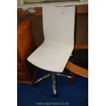 A white seat and chrome effect swivel chair.