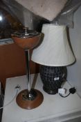 A table lamp and cream shade and an ashtray.