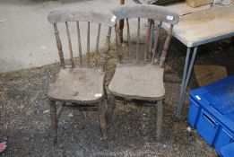 A pair of stick back kitchen chairs.