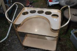 A retro gold coloured metal drinks trolley.