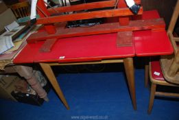 A red drop leaf formica top table 47" long x 24" wide x 30" high.
