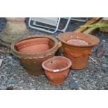 Five terracotta planters including two wall planters.