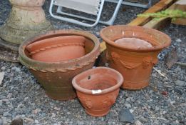 Five terracotta planters including two wall planters.