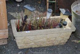 A concrete planter 26" x 11" x 10 1/2" h.