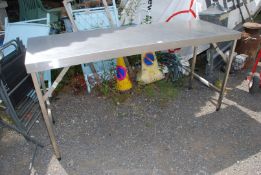 A stainless steel folding prep table, 71'' long x 23 1/3'' deep x 35 1/4'' high.