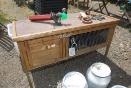 A wooden rabbit hutch on legs.