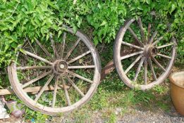 A pair of vintage spoked cartwheels with rubber tyres, some wood worm damage, 47" diameter.
