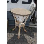 A cast metal table base with stone top,