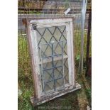 A framed leaded opening window with leaded panel.