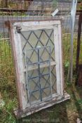 A framed leaded opening window with leaded panel.