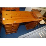 A pine desk having 8 drawers.