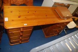 A pine desk having 8 drawers.