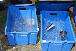 Two blue boxes of glass water jugs and chrome beakers.