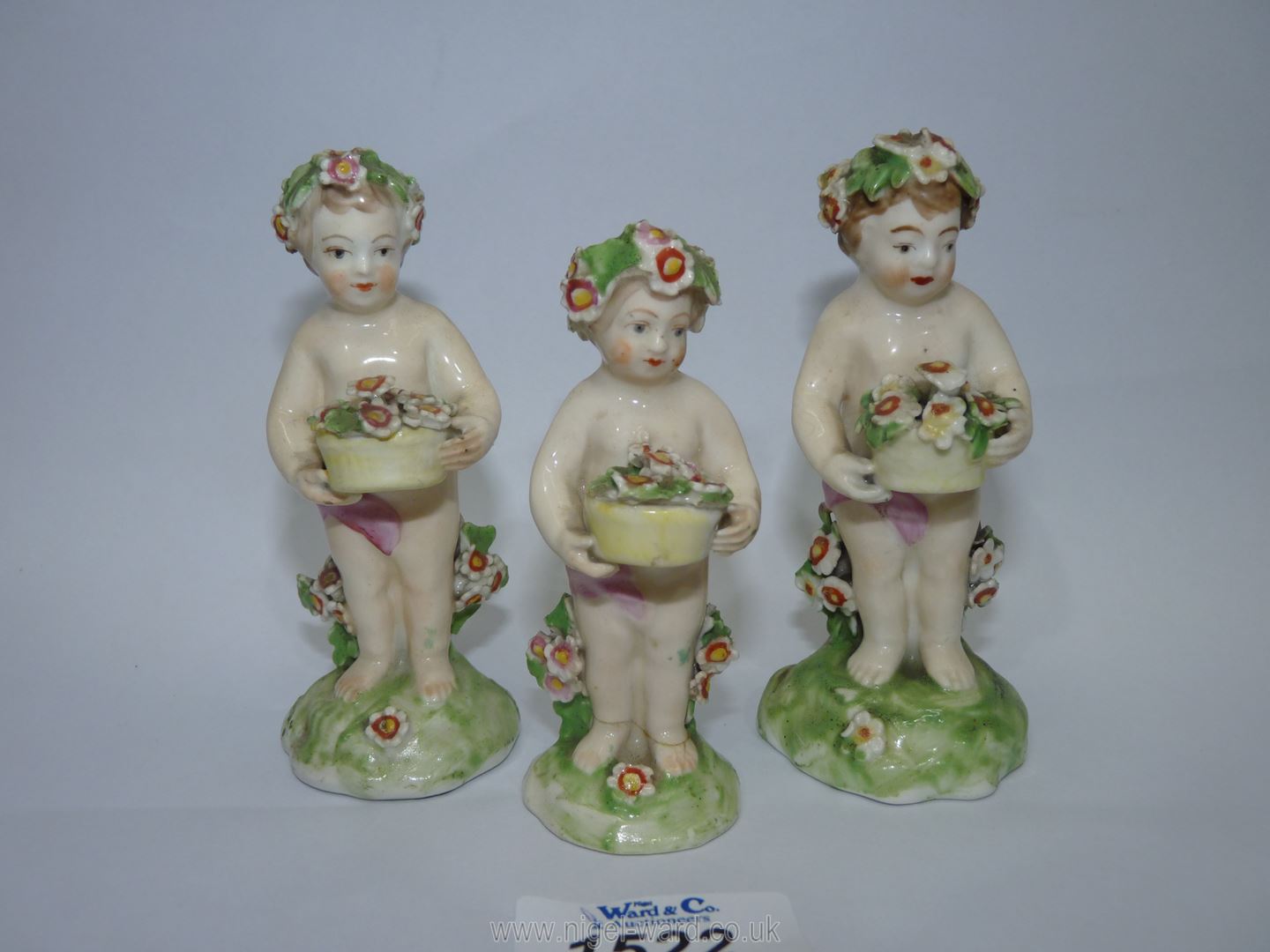 Three Derby porcelain Putti holding flower baskets, some damage, 4'' and 3 1/2'' tall. - Image 2 of 4