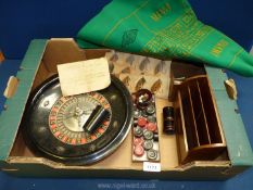 A vintage roulette wheel and green playing cloth, a set of draughts and a set of dominoes,