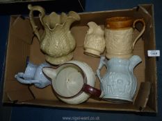 A quantity of applied relief moulded jugs in various sizes, most with hairline cracks and repairs.
