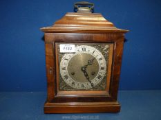 A British Anvil wooden mantle clock with Roman numerals having ornate metal surround to face,