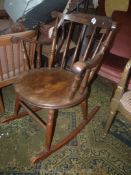 A circular seated Welsh cottage kitchen design Rocking Elbow Chair having turned legs, stretchers,