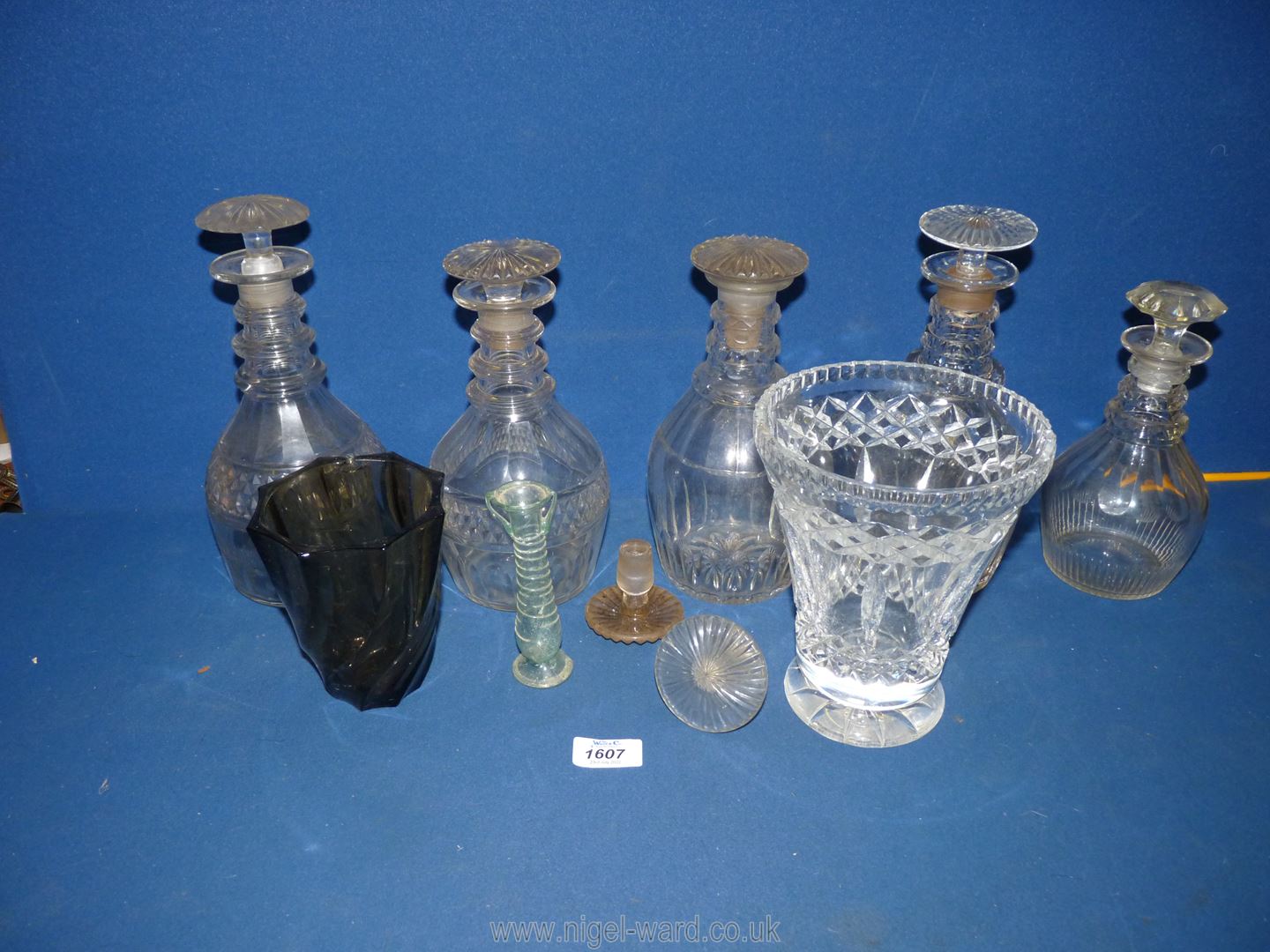 Five glass decanters with stoppers, 2 spare stoppers, together plus a heavy cut glass vase,