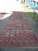 Two large carpets, one in pink, yellow and blue octagonal pattern, very worn (some holes),