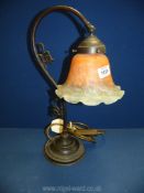 A table Lamp with orange glass shade.