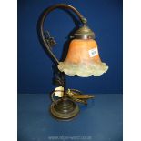 A table Lamp with orange glass shade.