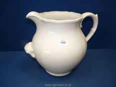 A very large cream coloured jug with a handle to front to assist with pouring, 12"tall.