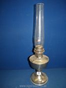 A metal based Oil lamp with glass chimney, single burner, 23'' high overall.