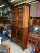 A Satinwood double height Bookcase having two pairs of opposing glazed doors giving access to