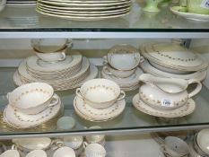 A Royal Doulton 'Citadel' six setting dinner service in cream with gilt leaf pattern and rims to