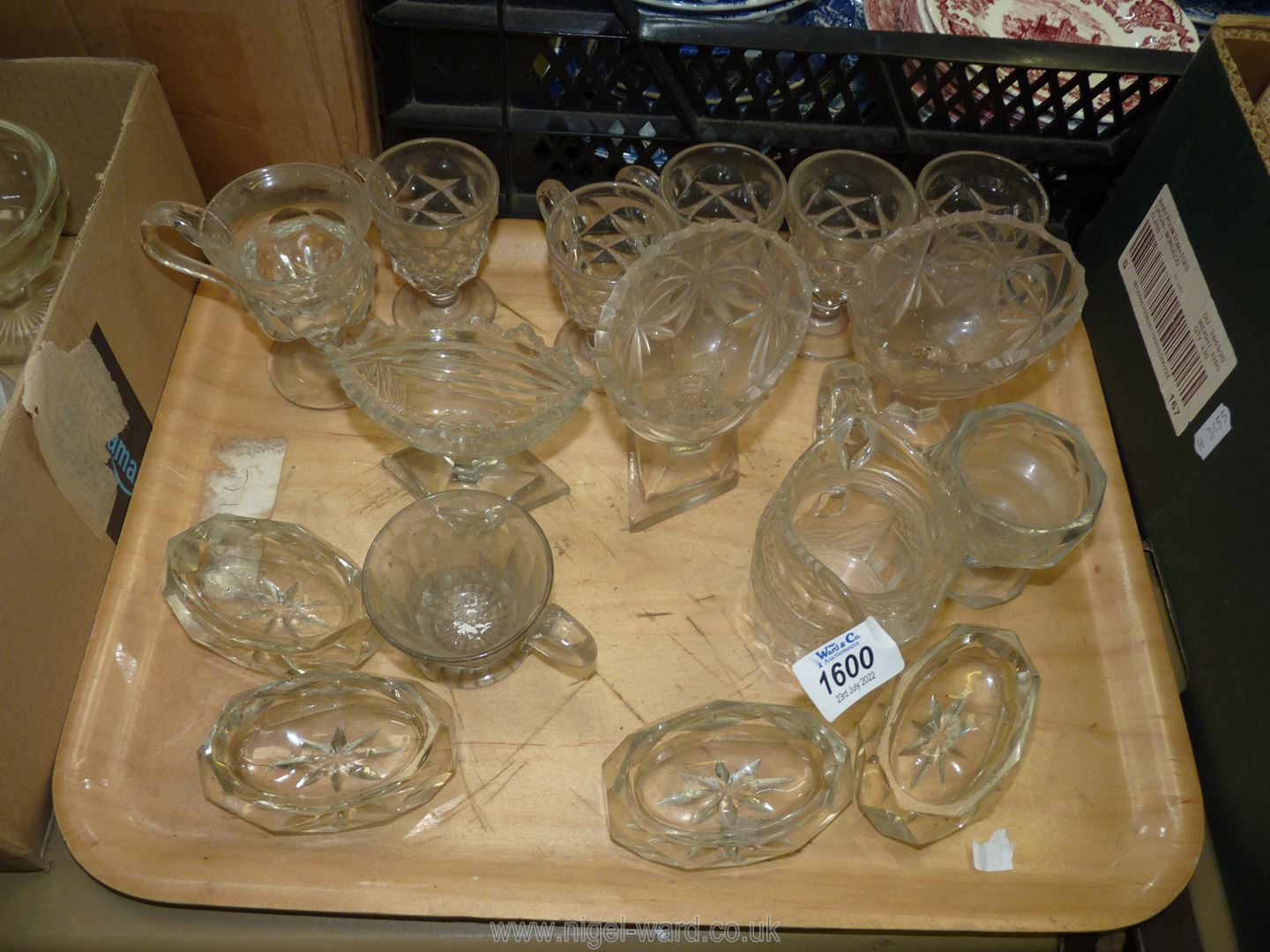 A tray of old pressed glass custard cups, salts and cream jug, some chips.