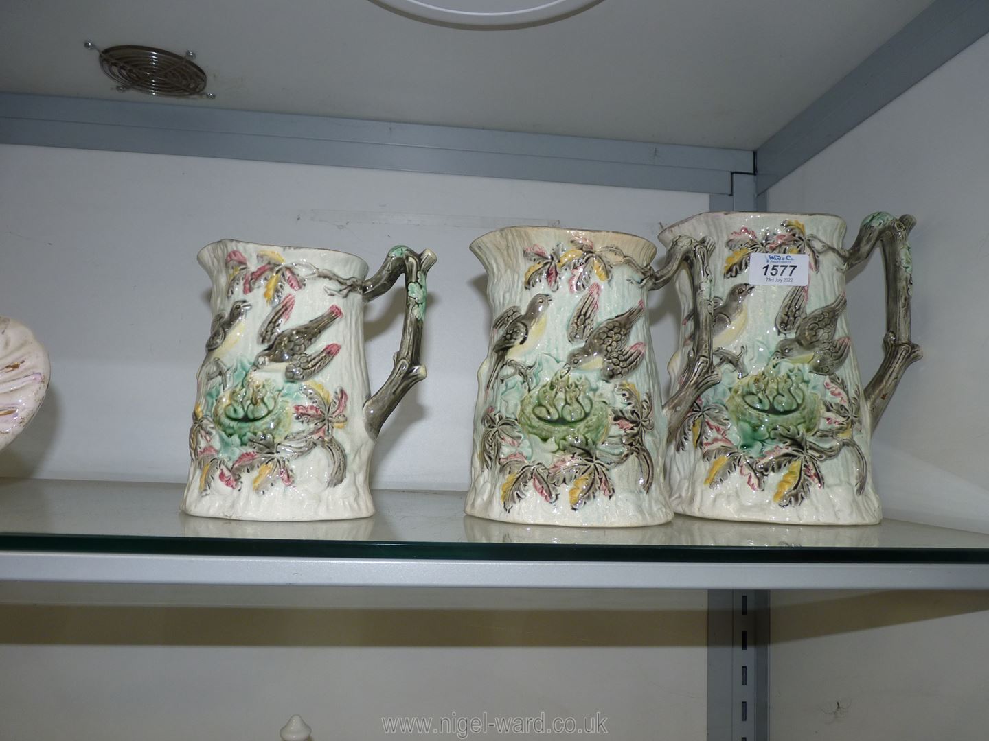 Three graduated jugs decorated with embossed birds feeding and chicks in a nest,