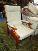 A golden coloured wood framed open armed fireside chair upholstered in pale beige.