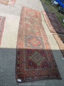 A red, blue and terracotta Runner, worn and fade, 12' long x 42'' wide.