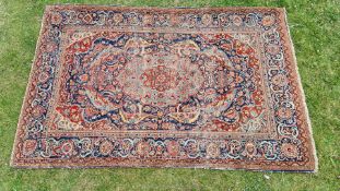 A terracotta ground isfahan pattern Persian rug with central medallion and floral borders, a/f.